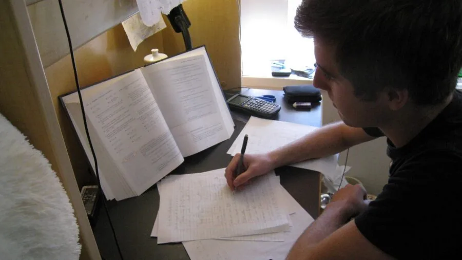 Person working on laptop at home desk, representing network prioritization and internet connectivity needs