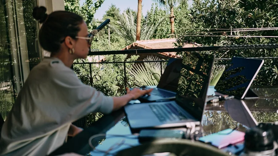 Person working on laptop in cafe, checking battery life and time management during workday