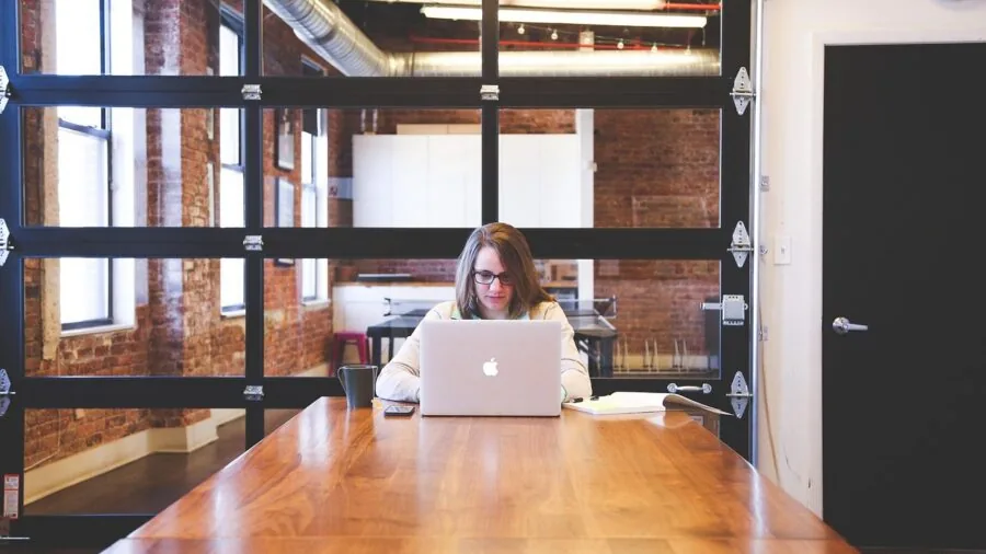 Person working on laptop outdoors during daytime, depicting long battery life and portability for extended work sessions