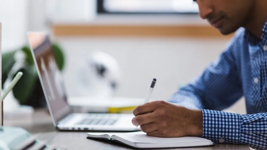 Person working on laptop outside with natural lighting, focused on productivity and device efficiency