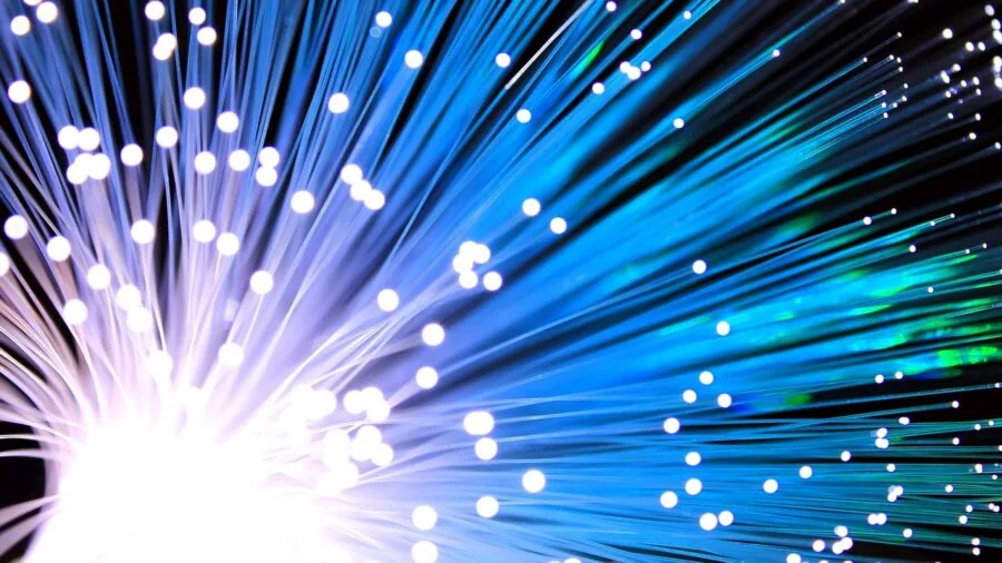 Person working on laptop with digital speed lines representing fast data transfer and file loading