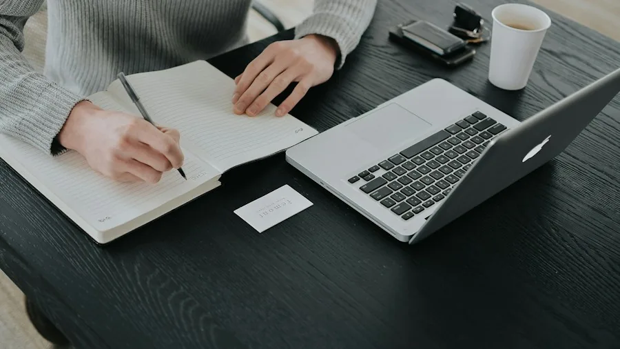 person working on laptop with notes