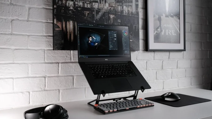 Person working on photo editing at a home office desk with natural lighting