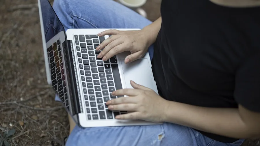 person working on portable computer outdoors