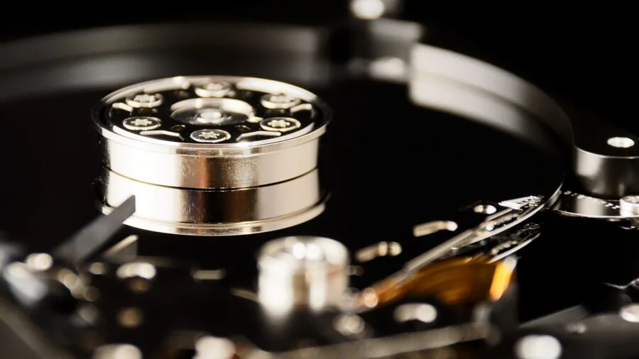 Person working with computer components and storage devices on desk workspace