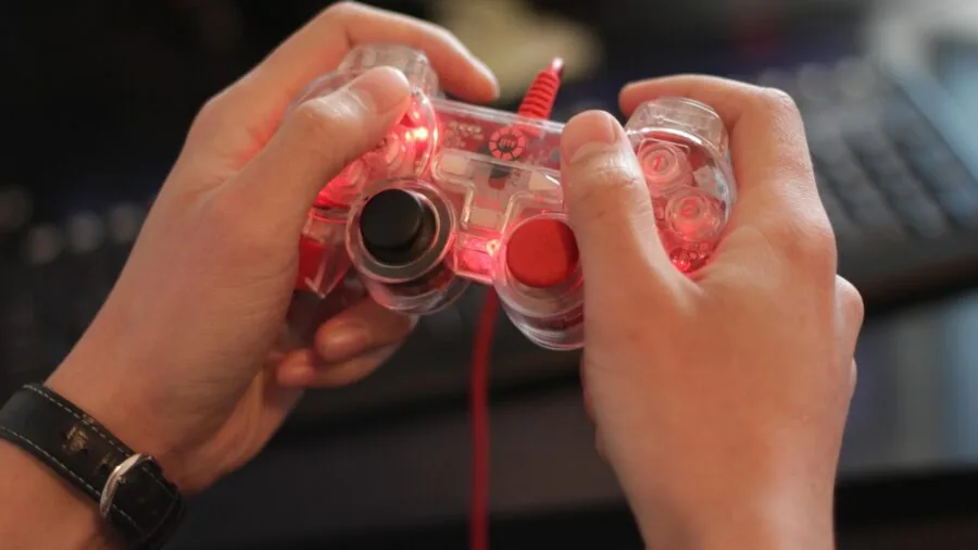 Person's hands gripping a gaming controller during an intense gameplay session, focusing on ergonomic grip and button control