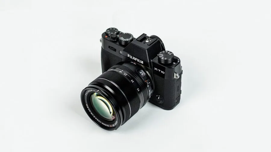 Photographer holding mirrorless camera while shooting in natural outdoor setting