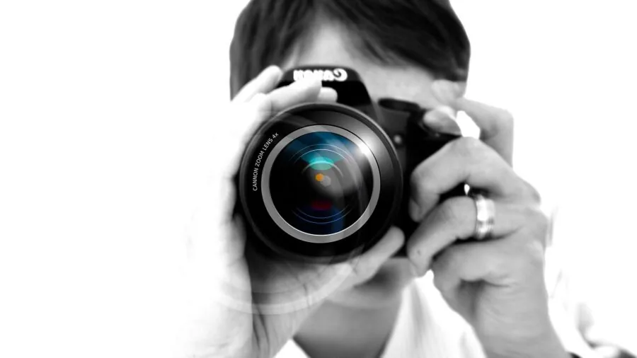 Photographer importing photos from camera to laptop in natural outdoor setting