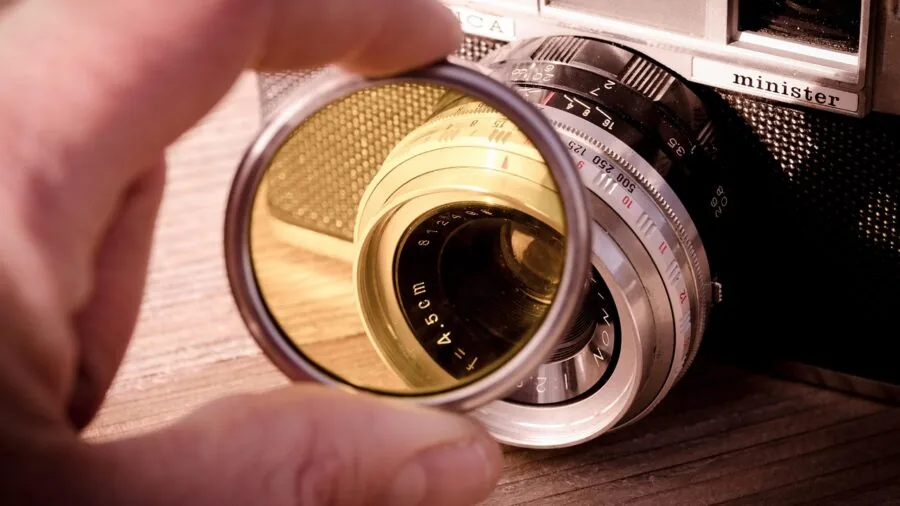 Photographer packing travel camera equipment into backpack for trip