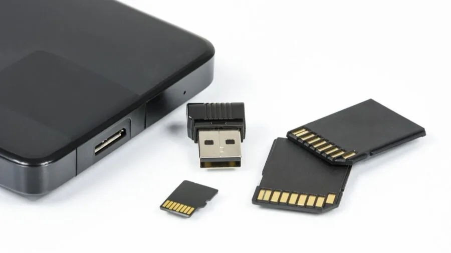 Photographer reviewing and organizing digital photos on computer with external storage devices