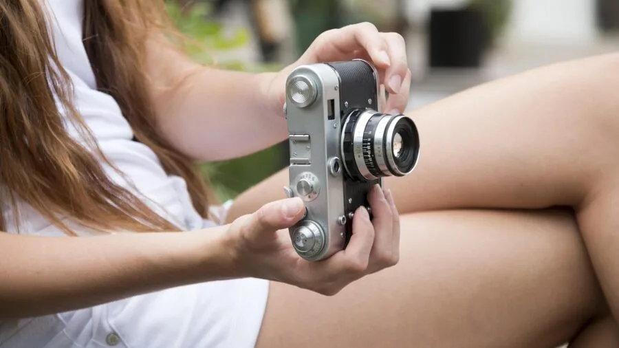 Photographer reviewing and transferring images wirelessly on laptop in creative workspace
