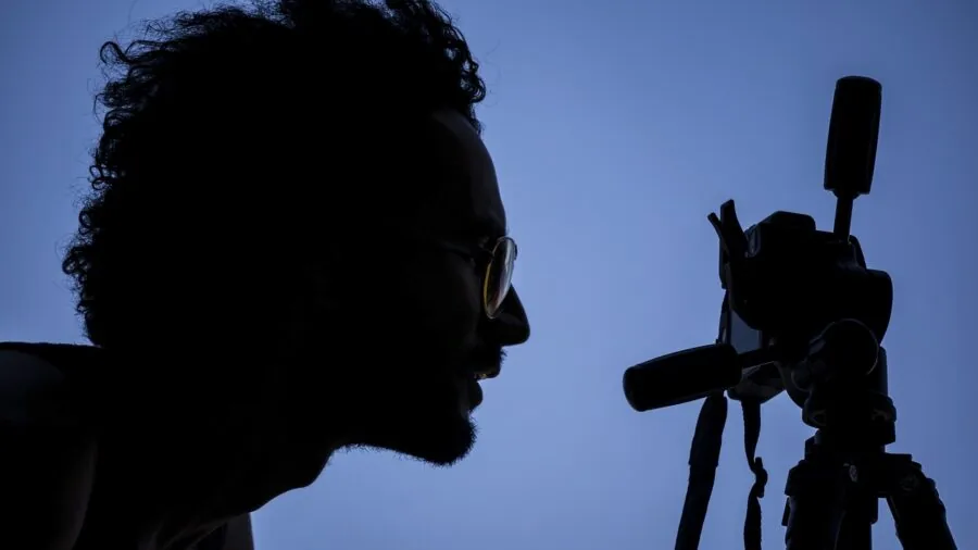 Photographer setting up tripod for landscape photography in natural outdoor environment