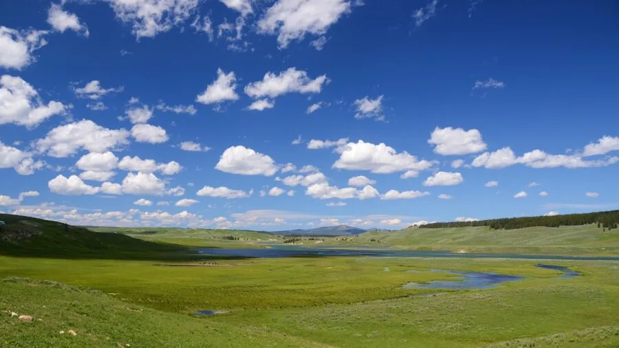 Photographer taking landscape photos with wide-angle perspective of natural scenery and mountains