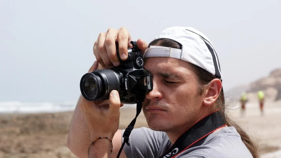 Photographer using DSLR camera and smartphone together for content creation in natural setting