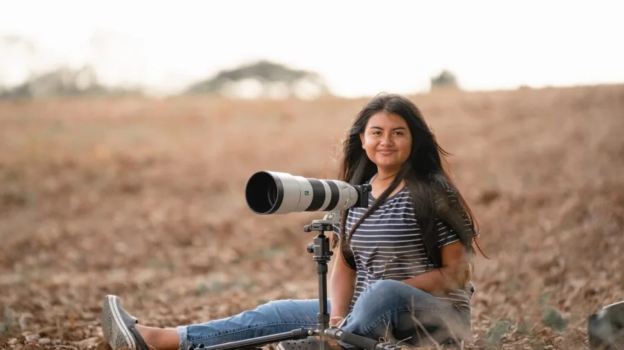 Photographer using telephoto lens to capture distant mountain landscape scenery