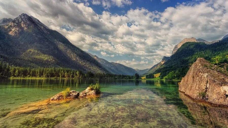 Photographer with camera capturing expansive mountain landscape with wide field of view