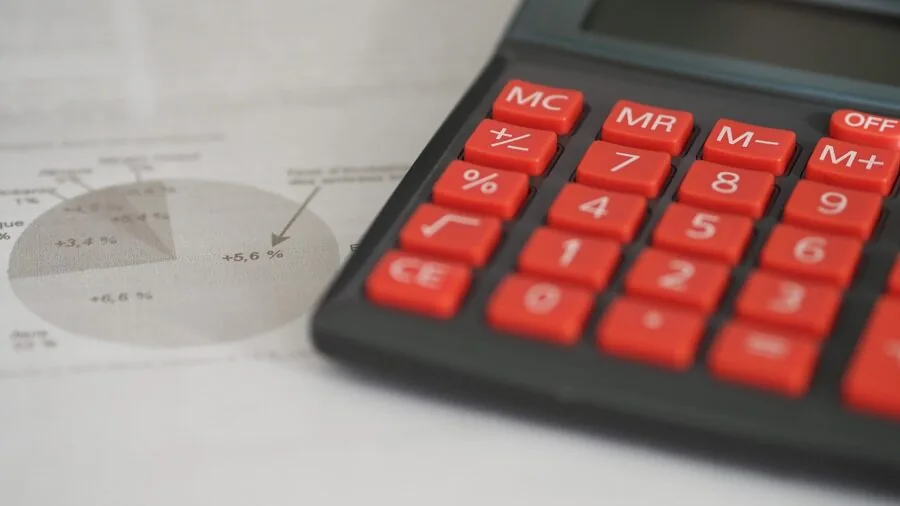 Professional at desk analyzing financial spreadsheet data with focused concentration in modern office environment