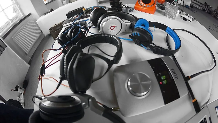 Professional audio engineer working at recording studio mixing console with microphone and XLR cables