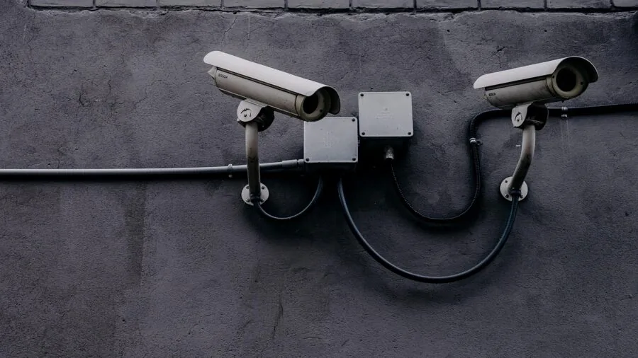 Professional checking security camera feed on mobile phone in office environment