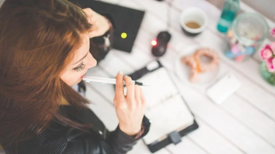 Professional focused on laptop work at desk in modern workspace environment