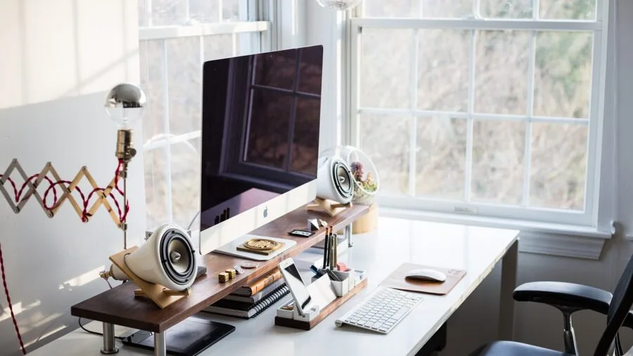 Professional home office setup with curved monitor displaying work application on desk