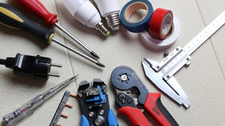 Professional installing electrical wiring on exterior house wall for security system