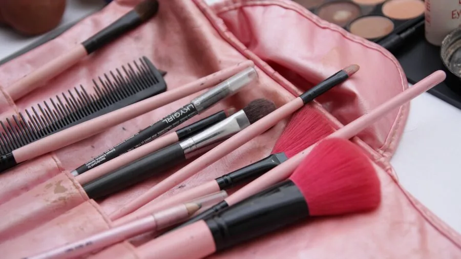 Professional makeup artist applying foundation under bright studio lighting during beauty tutorial session