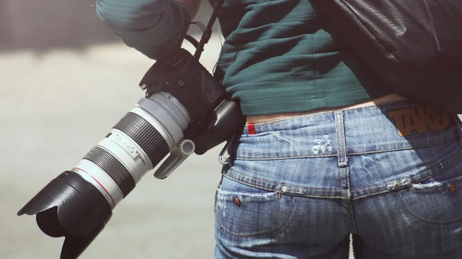 Professional photographer carrying gear and lighting equipment while traveling between studio and client shoot locations