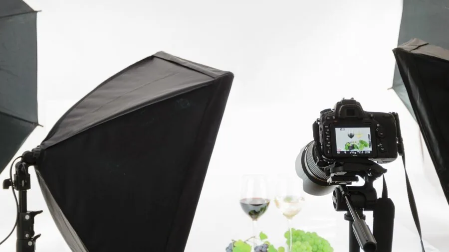 Professional photographer positioning softbox lighting in creative studio workspace