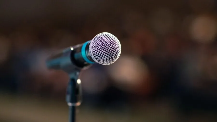 Professional speaker using wireless microphone during live presentation on stage