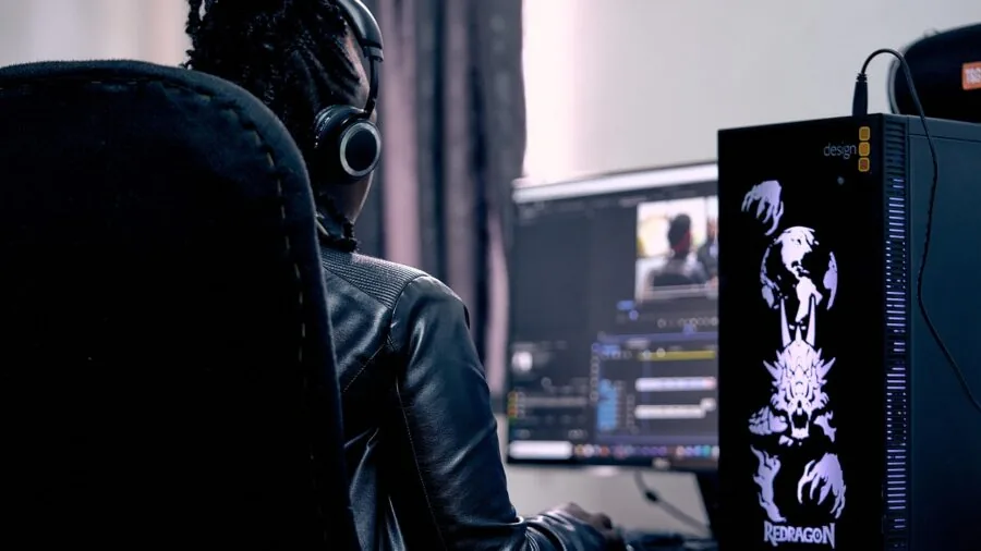 Professional video editor working at desk with color-graded footage displayed on monitor