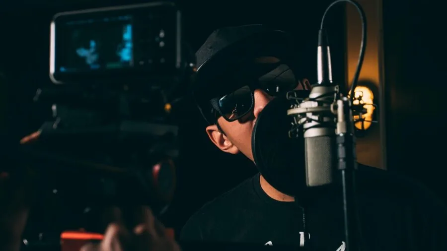 Professional vocalist performing with microphone in recording studio setup