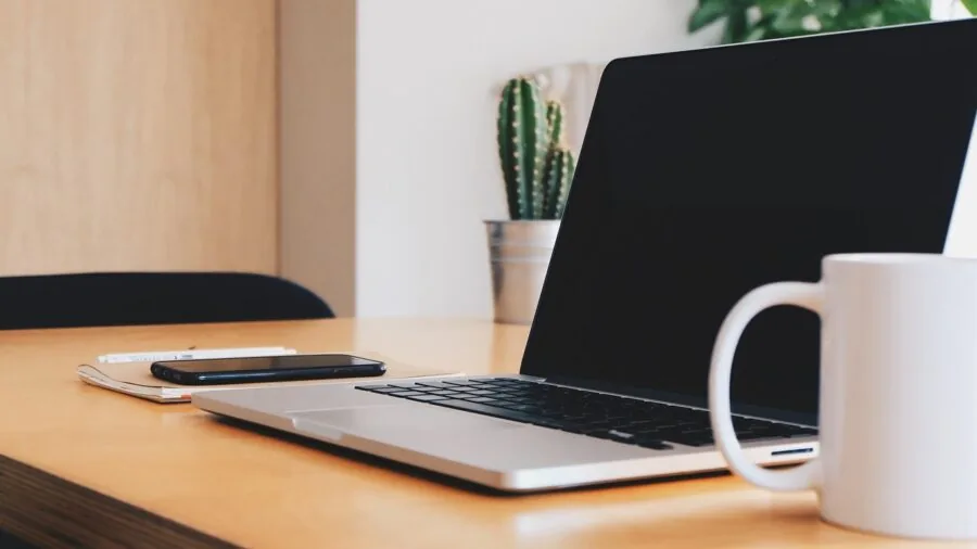 Professional working across multiple devices and platforms on desk setup