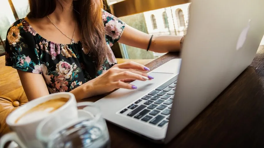 Professional working intently on laptop at desk, focused on screen during work session