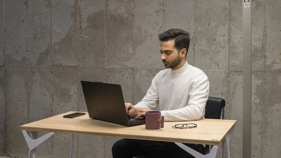 Professional working on laptop at desk in modern workspace