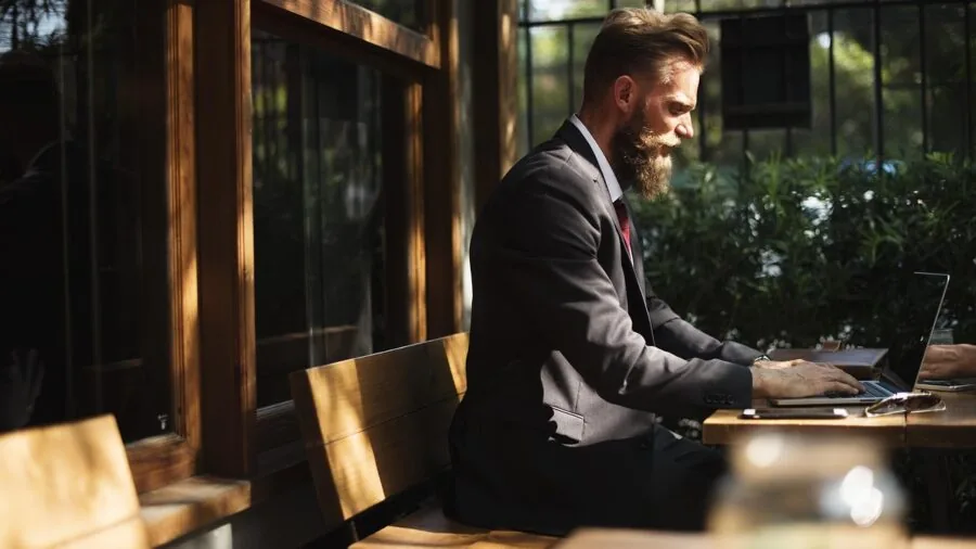 Professional working on laptop outdoors with clear screen visibility in natural daylight