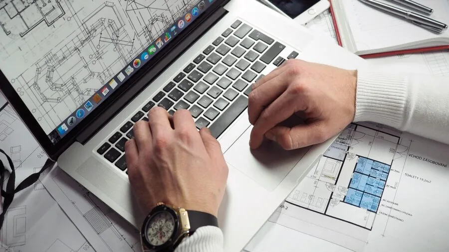 Professional working on laptop with external storage devices, representing data management and technology reliability