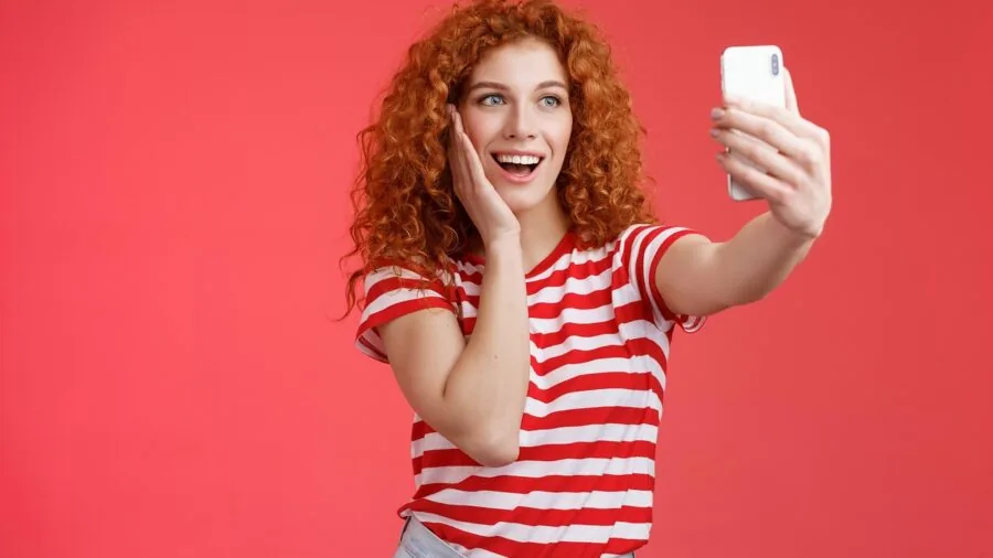 Senior person smiling while using smartphone with clear, easy-to-read interface on screen