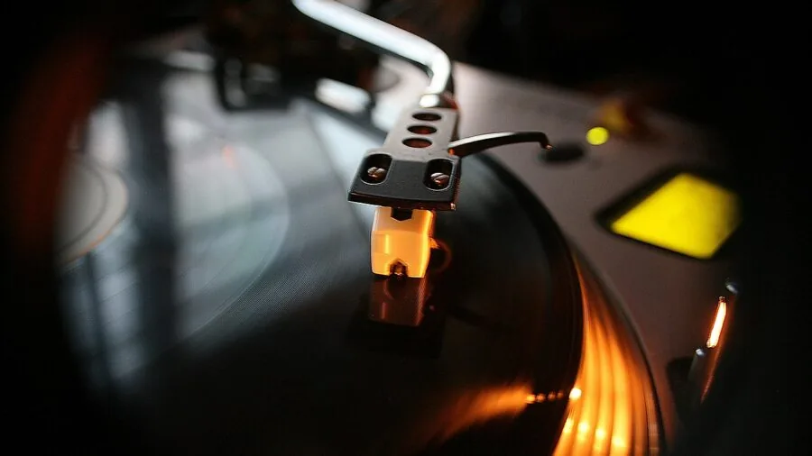 Someone carefully connecting cables to audio equipment during home music setup