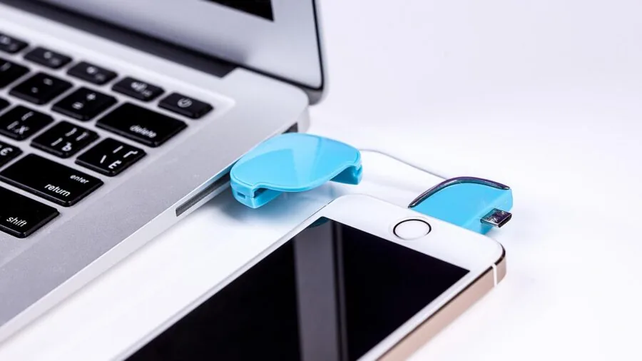 Someone plugging in a wireless keyboard with USB-C cable at a desk workspace