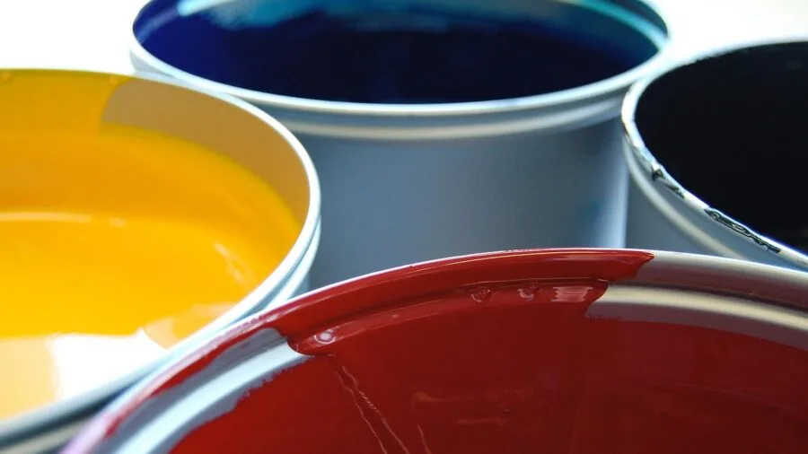 Someone reviewing printed color photographs at a home desk with natural lighting