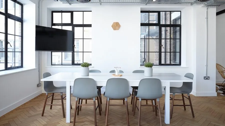 Spacious desk workspace with large monitor setup and organized cable management in bright room