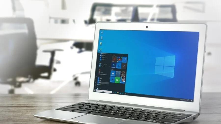 Student comparing computer options while studying at desk with notebook and coffee