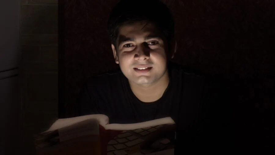 Student focused on laptop screen while working on coding project at desk