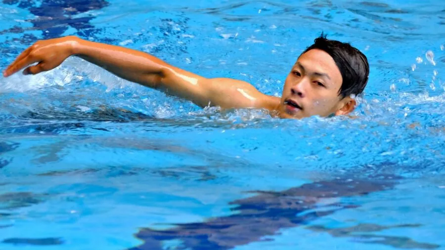 Swimmer doing laps in pool wearing sports watch during workout session