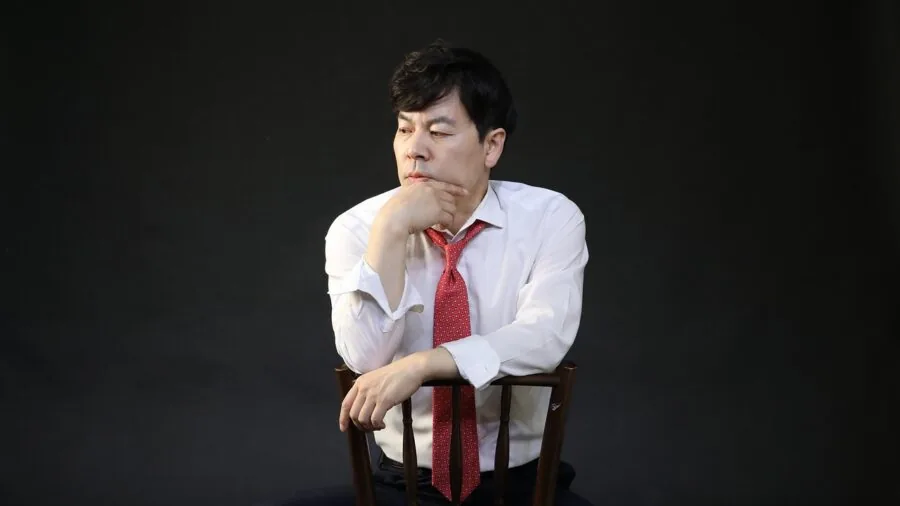 Tall man demonstrating proper seated posture with back support and neck alignment in comfortable chair