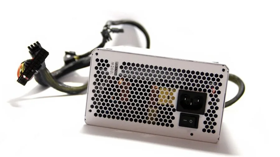 Tech enthusiast carefully installing a power supply unit inside a desktop computer case in a home workspace