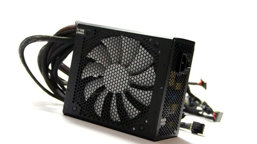 Technician installing power supply unit inside desktop computer tower during assembly