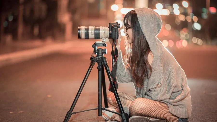 Videographer quickly transitioning camera from tripod to handheld shooting during outdoor production