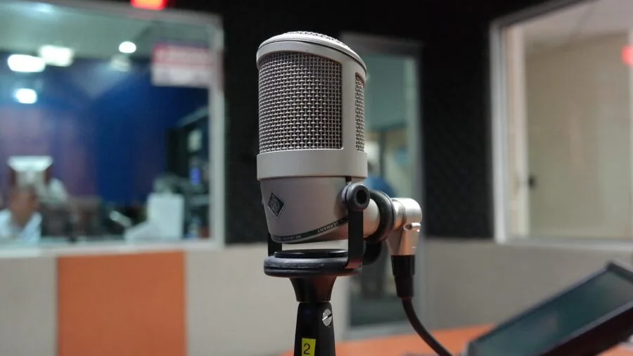 Vocalist performing at microphone in professional recording studio during vocal session